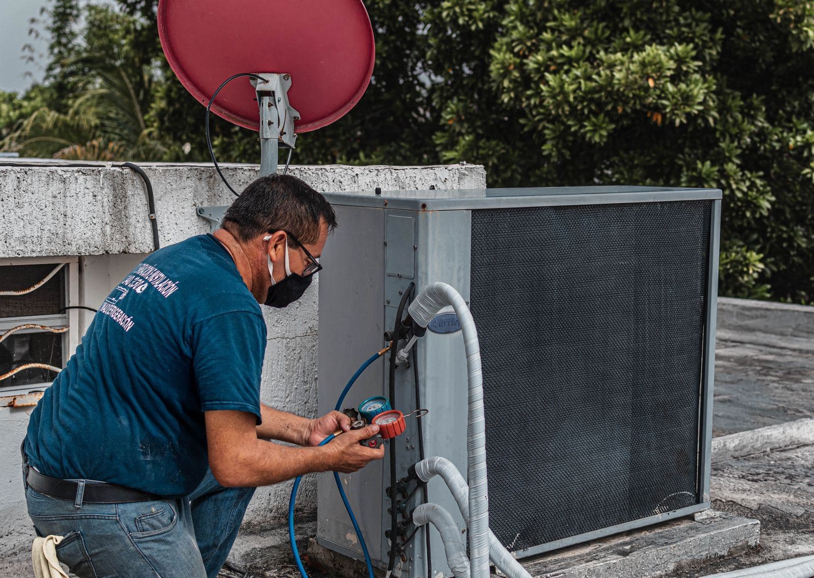 Technician checking refrigerant pressures with a manifold gauge